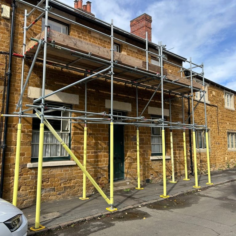 Scaffolding surrounds a two-storey brick building under renovation.