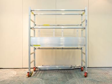 Aluminium scaffold with three levels and wheels for mobility.